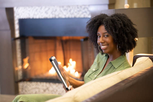 istock Black Female Browsing a Tablet in a Living Room 1150847560