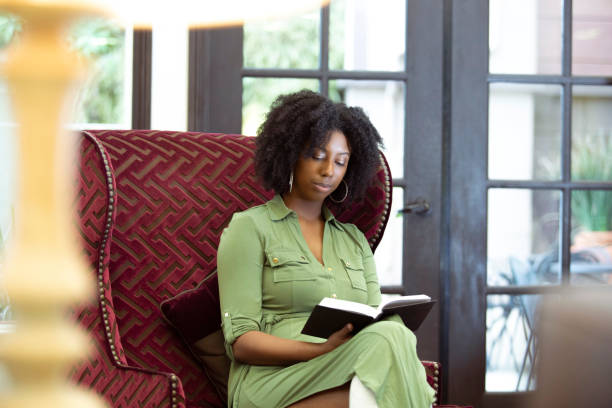 istock Black Female Reading a Book at Home 1150847600