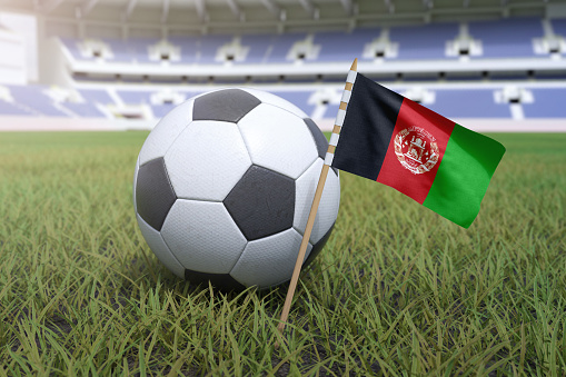 Afghanistan flag in stadium field with soccer football