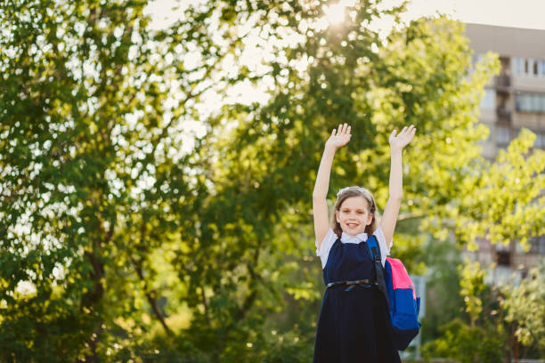 istock happy schoolgirl with raised hands up 1150863129