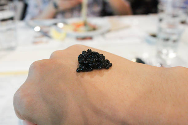 caviar colocado na mão de volta - heap caviar animal egg fish roe - fotografias e filmes do acervo