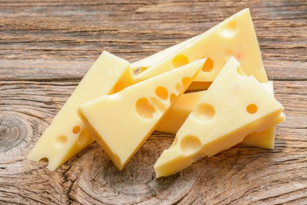 ser z otworami dużymi i małymi na drewnianym tle - cheese portion emmental cheese yellow zdjęcia i obrazy z banku zdjęć