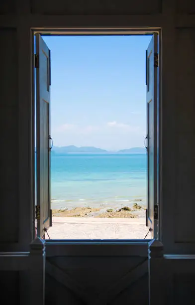 Photo of open the window ,blue sea ,blue sky , view background .Summer, Travel, Vacation and Holiday concept