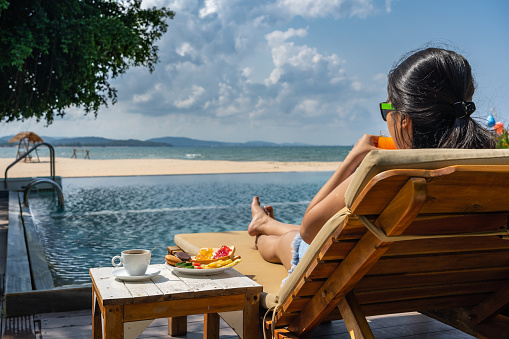 Rear view of young woman enjoy summer holiday vacation at the resort