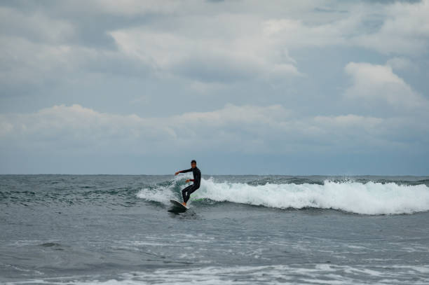 istock Determined man surfing in sea at beach 1150872986