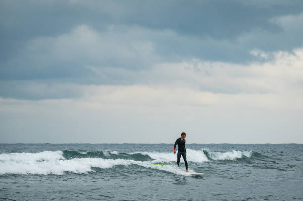 istock Determined man surfing in sea at beach 1150872987