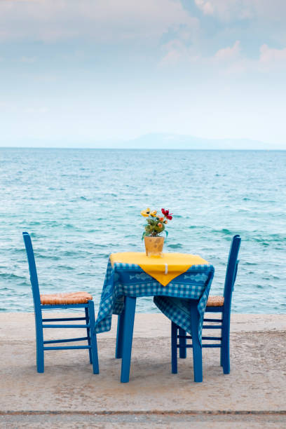 table for two in sidewalk cafe by the sea - greek culture bar restaurant greece imagens e fotografias de stock