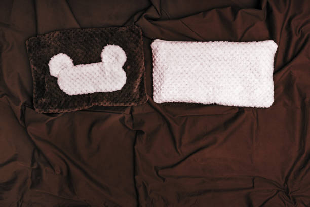 istock Fluffy mask for sleeping and cushion for two people on cotton sheet. Items for resting or sleeping. Top view. Flat lay. 1150882923