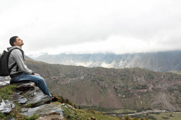 istock tourist man with a backpack against the Caucasus Mountains 1150888067