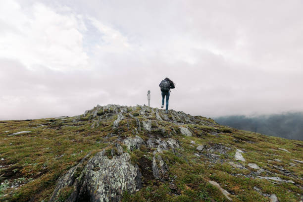 istock woman climbs to the binoculars on a hillside 1150888183