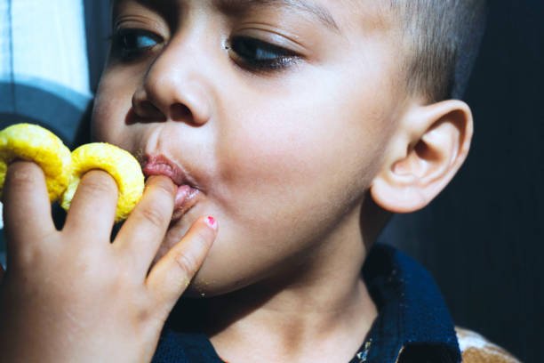 lindo niñito comiendo el anillo de hojaldre - eating child cracker asia fotografías e imágenes de stock