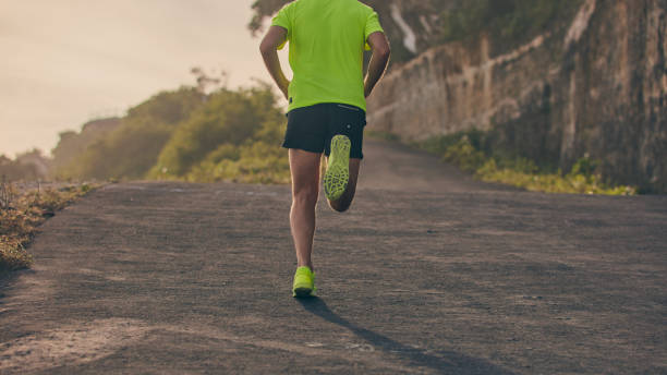 istock Man jogging on a downhill / uphill in suburb mountain road. 1150889998