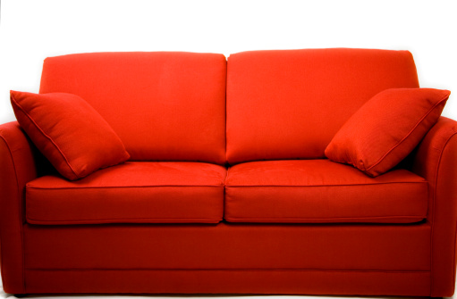 Cropped view of pillows and blanket on modern soft sofa in living room. House after renovation. Relax concept. Home comfort. Apartment interior details. Hotel room