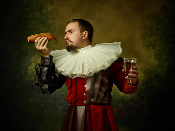 junger mann als mittelalterlicher ritter auf dunklem hintergrund - wearing hot dog costume stock-fotos und bilder