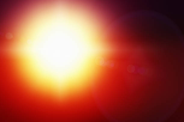 istock Intensely bright yellow sun with lens flare on red 1150908912
