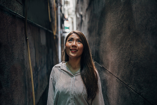 One woman, beautiful young woman standing the alley in Taipei on a rainy day.