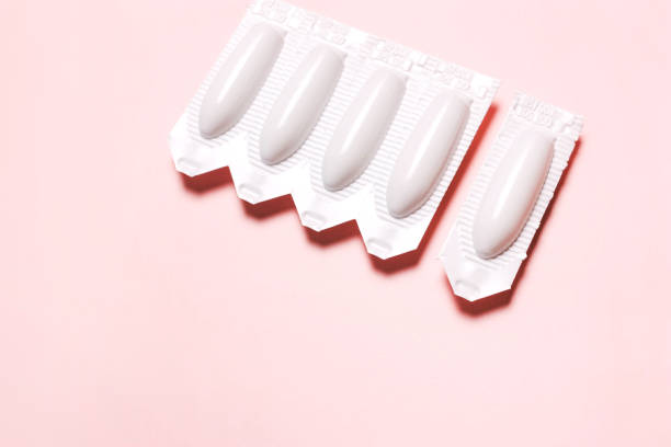 supositorio vaginal sobre un fondo rosado, para el tratamiento de las hemorroides, candidiasis - vagina contraceptive gynecologist doctor fotografías e imágenes de stock