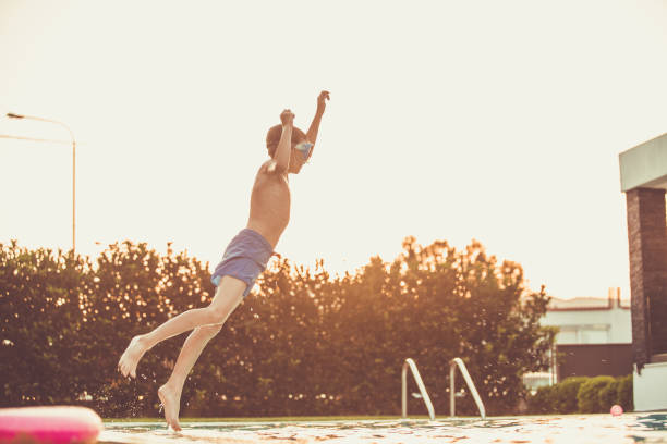 istock Boy jumping in the swimming pool 1150912221