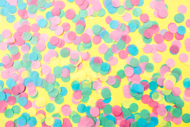 istock Multicolored confetti on a yellow background. Festive concept 1150913128
