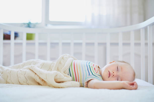 istock Baby sleeping in co-sleeper crib attached to parents' bed 1150917069