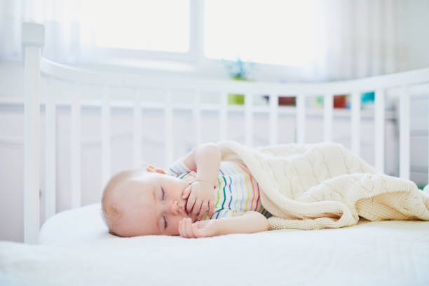 istock Baby sleeping in co-sleeper crib attached to parents' bed 1150917141