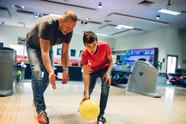 bowling de père et de fils - teenager team carefree relaxation photos et images de collection