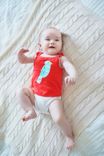istock Cute baby girl lying on her back on bed 1150918053