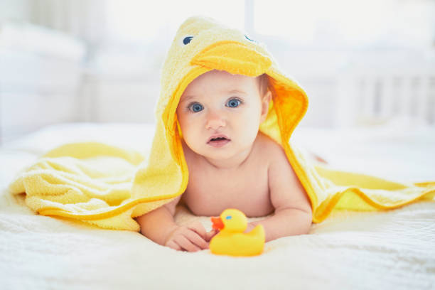 istock Cute little girl playing with rubber duck after having bath 1150918376