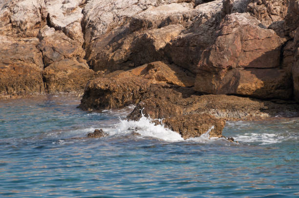 istock island's rocks violently touched by the water 1150919976