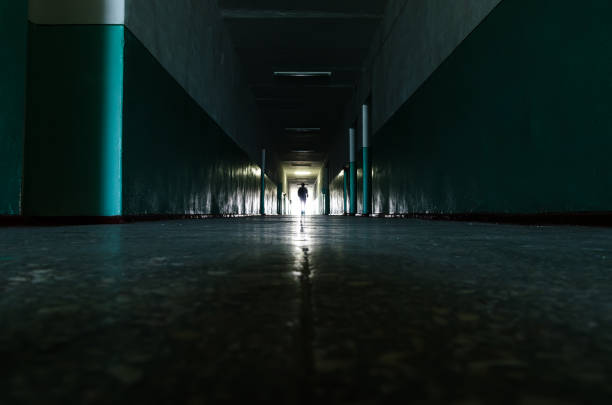 istock a long dark corridor as the path to infinity with the human body at the light end 1150921140