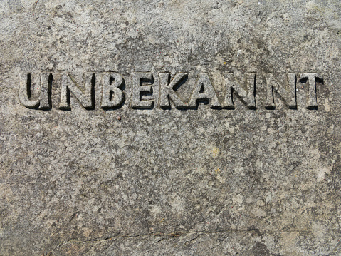 the word unknown carved in the ancient gravestone of the unknown soldier