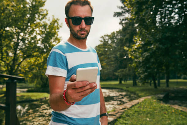 istock Trendy man using cellphone outdoors. 1150921438