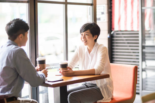 istock Two people enjoy a conversation in a coffee shop. 1150927685