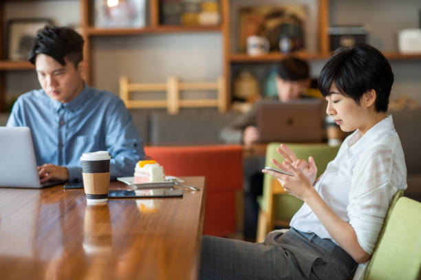 istock Women is looking at her mobile phone, surrounded by coworkers. 1150928247