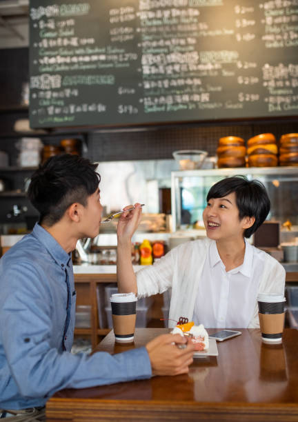istock Two people share a cake in a coffee shop. 1150929017