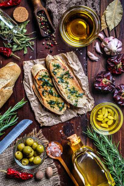 aperitivo o aperitivo de albahaca de ajo y bruschetta de aceite de oliva en la mesa en una cocina rústica - bruschetta cutting board italy olive oil fotografías e imágenes de stock