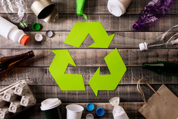 Top view of Different garbage materials with recycling symbol on table background. Recycle, environment and Eco concept