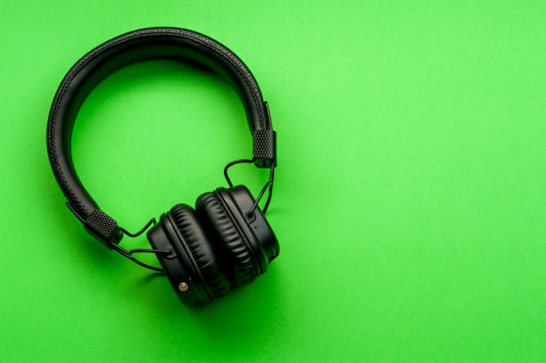 istock Black stylish headphones on green background. 1150932650