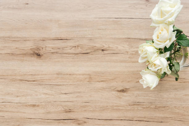 istock Top view of fresh white roses on wooden surface 1150934456