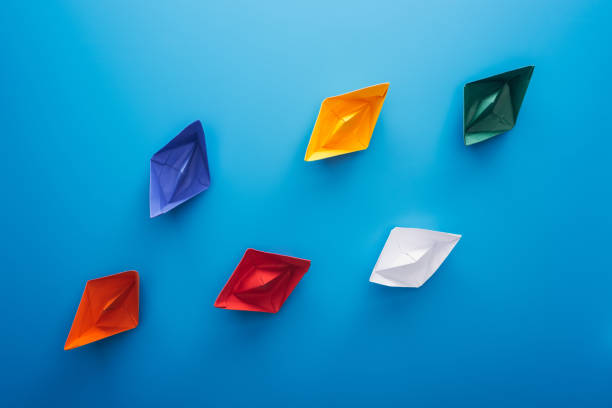 istock Flat lay with colorful paper boats on blue surface 1150934832