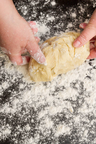 istock Preparation of cottage cheese dough on a black table with scattered flour 1150934844