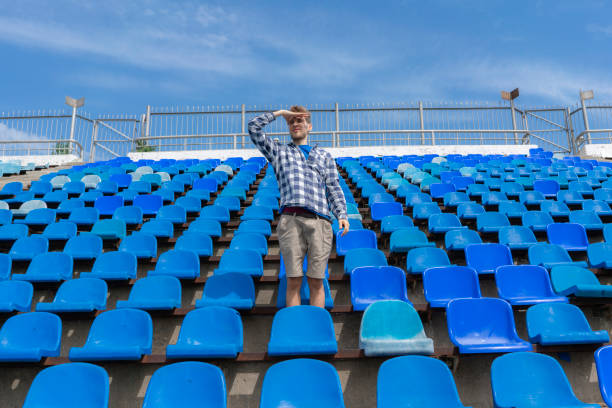 istock lonely man on the empty stadium seat cheering for the team, one man army concepts 1150934927