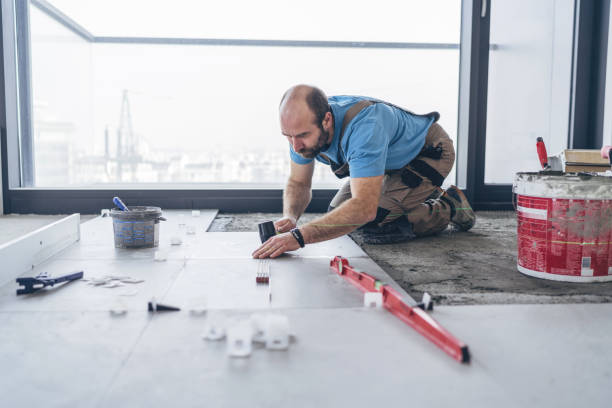 istock Male builder adjusting floor tiles with mallet 1150935046