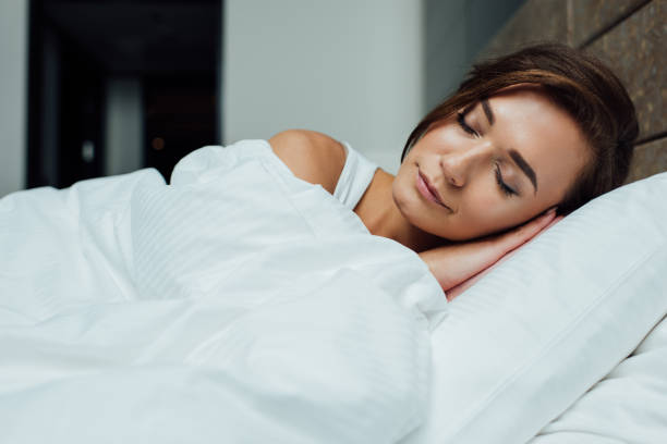 istock beautiful brunette woman sleeping on pillow under blanket in bed 1150936164