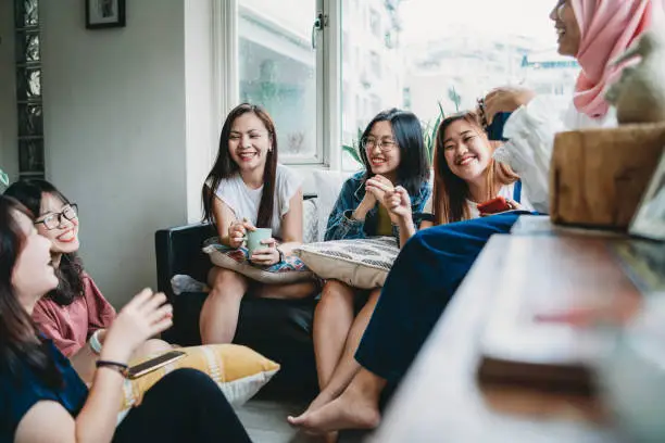 Photo of Friends talking and drinking coffee at home