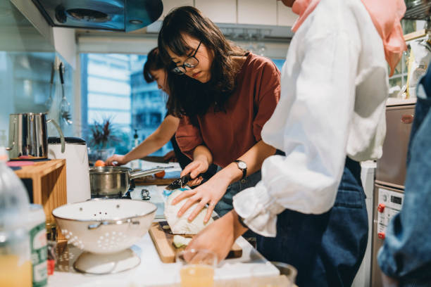 istock Group of friends preparing dinner together in the kitchen 1150936785