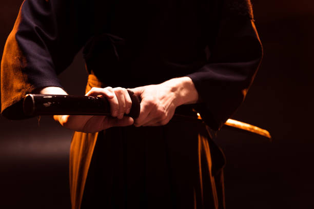 istock Partial view of kendo fighter holding bambo sword on black 1150936929