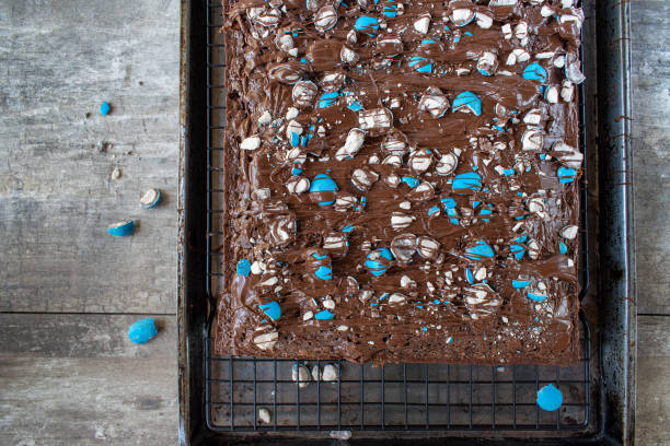 brownie sheet cake with bright blue candy pieces and drizzled chocolate on top