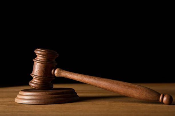 istock brown wooden gavel on table isolated on black with copy space 1150937364