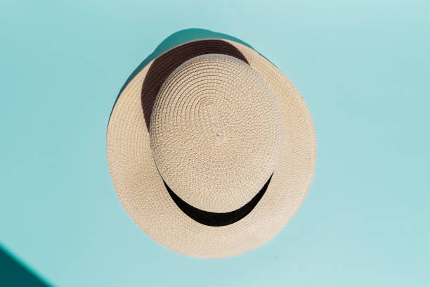 istock Straw hat on coral living color background direct sunlight, objects for summer. 1150939993